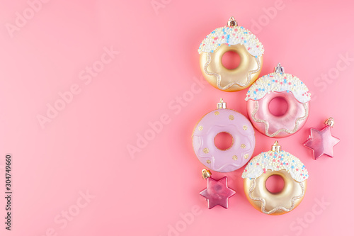 New Year donut-shaped Christmas tree toys on a pink pastel background.