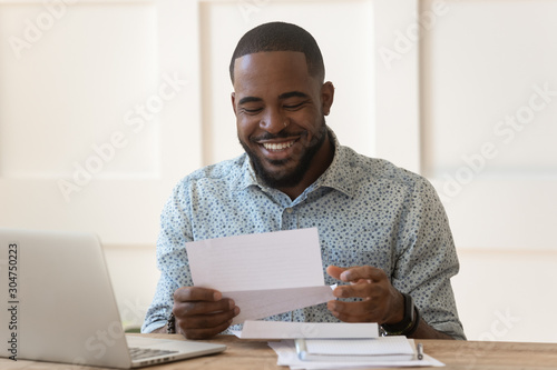 Happy biracial man feel excited get good news in letter