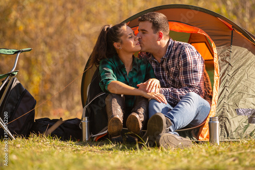 Couple in love kissing in front of the tent