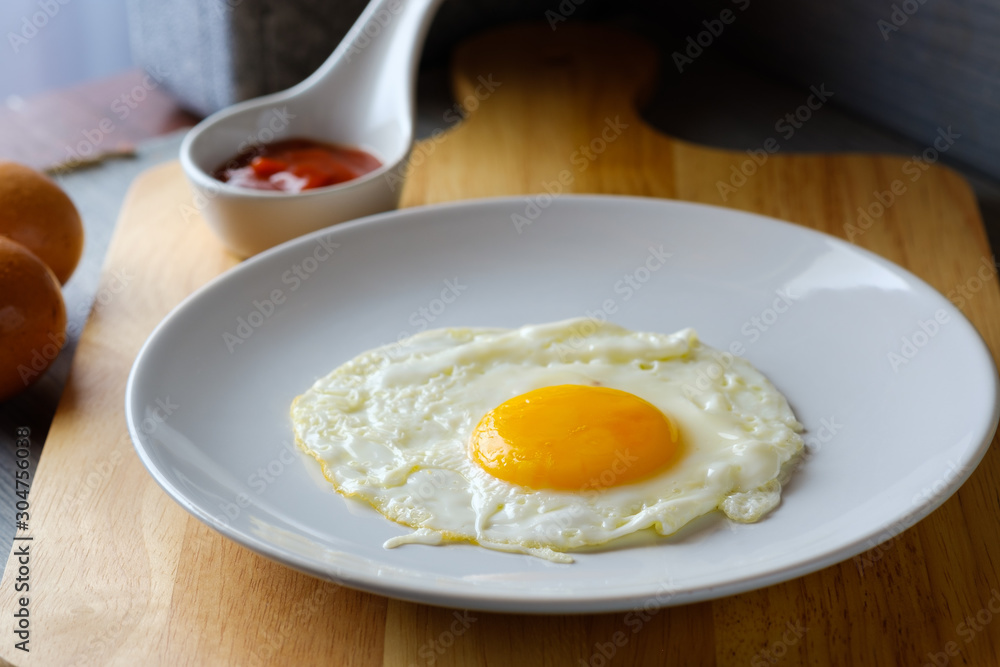 Close up fried egg is in a white round dish placed Close up fried egg is in a white round dish placed