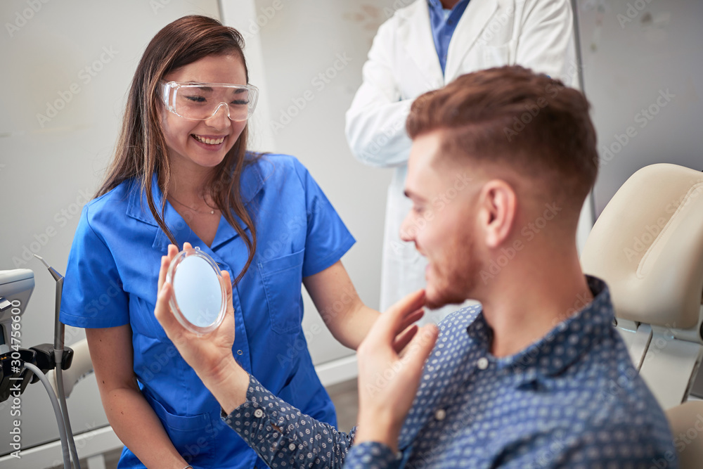 Fototapeta premium Doctor dentist showing patient's his whites teeth