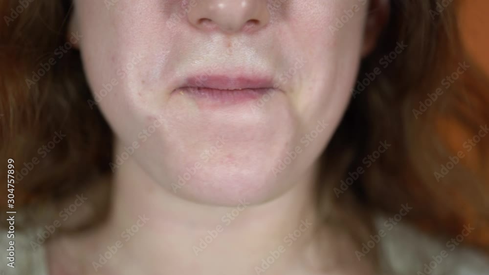 A portrait of the female body part on an orange background. A young woman is eating the breaded chicken nuggets. Close up of the mouth. A portrait of the female body part on an orange background. A young woman is eating the breaded chicken nuggets. Close up of the mouth.