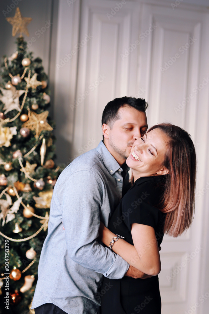 Beautiful young couple in Christmas. A young woman and a man are smiling and having fun together.