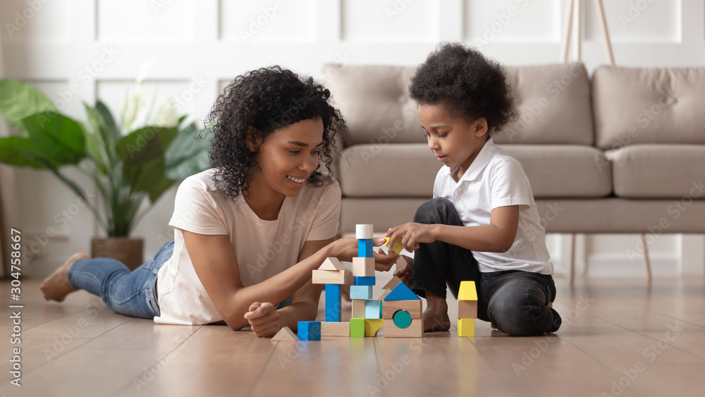 Mother and son play with blocks set on warm floor Mother and son play with blocks set on warm floor