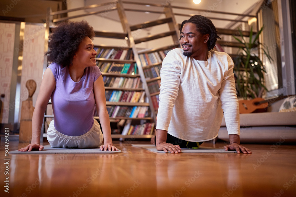 Couple exercising doing yoga together at home Couple exercising doing yoga together at home