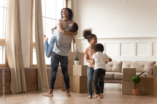 Mixed-race family fooling around having fun celebrating relocation day