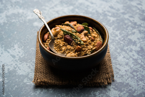 Oats Chivda / Chiwda is a healthy indian recipe with added chilli, peanuts, cashew, almond and curry leaf for flavour. Selective focus photo