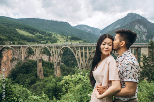 Young beautiful couple hugs on the background of the Dzhurdzhevich bridge in Montenegro. photo