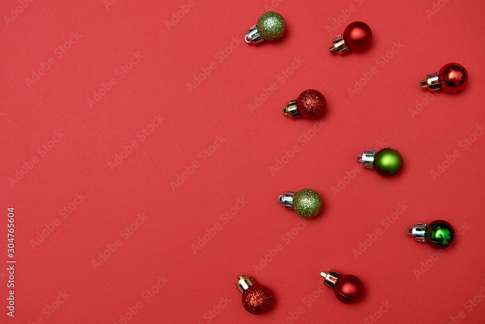 Creative Christmas pattern with red and green shiny baubles on red background, copy space. Minimal, winter, new year concept. Top view, flat lay Creative Christmas pattern with red and green shiny baubles on red background, copy space. Minimal, winter, new year concept. Top view, flat lay