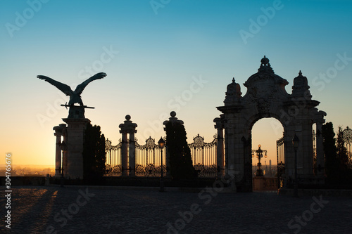 silhouette of the Turul Bird Statue and gate to the Royal Palace on the sunrise photo