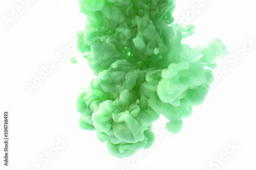 Abstract flowing liquid or green ink in water on a white background. It looks like smoke or cloud. Or zero gravity. photo