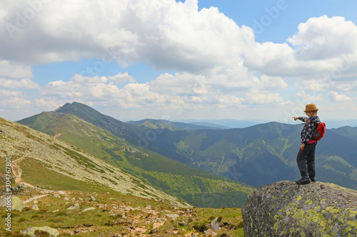 Girl standing on the hill  watching mountain view, showing the trail