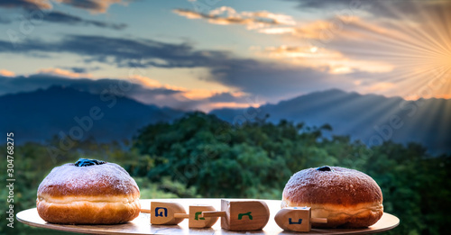 Attributes for Jewish Holiday Hanukkah against blurred mountains and sunrise