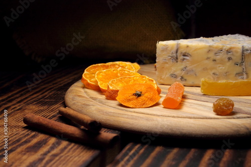 Кусочки сыра Бри с плесенью и сушеные фрукты на деревянной доске