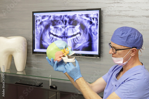 Middle age dentist preparing treatment plan in his office	
