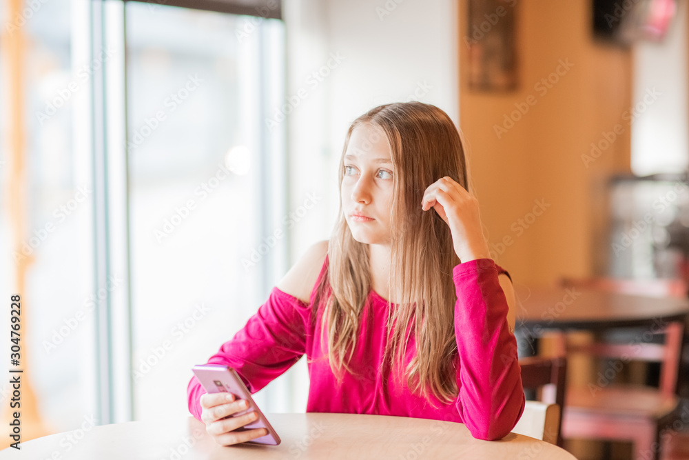 beautiful, sad, serious teenager girls, sitting in cafe and looking on window beautiful, sad, serious teenager girls, sitting in cafe and looking on window