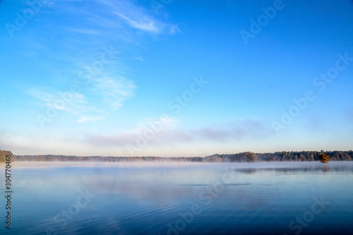 Misty Morning Lake with Autumn Colored Trees and Foliage