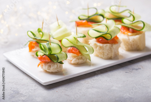 Christmas tree canape or sandwich with cucumber slice, salmon  for festive x-mas snack. New year recipe photo