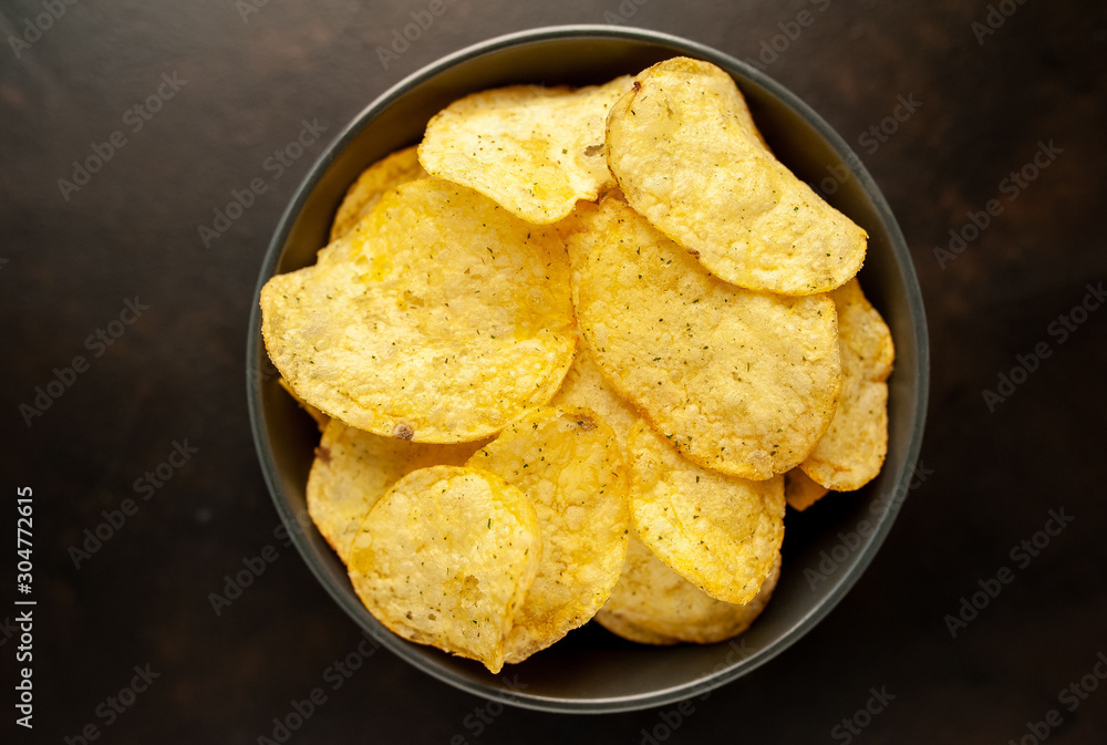 potato chips in a bowl, beer snacks on a stone background potato chips in a bowl, beer snacks on a stone background
