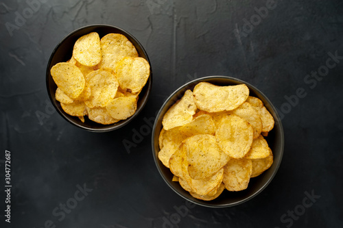 potato chips in two bowls, beer snacks on a stone background