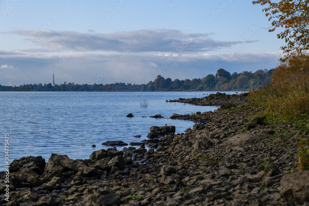 Rocky Shore of a wide and calm river on a summer evening