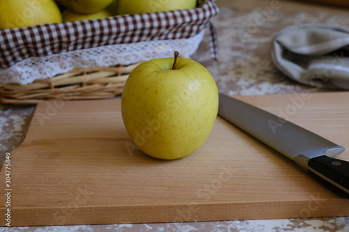 Knife and apple on a cutting board on a table in the kitchen. Chantecler apples. photo