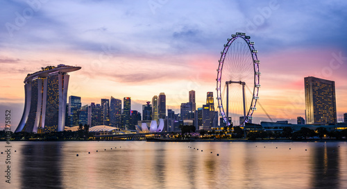 Stunning view of the illuminated skyline of Singapore during a beautiful and dramatic sunset. Singapore is an island city-state off southern Malaysia. © Travel Wild