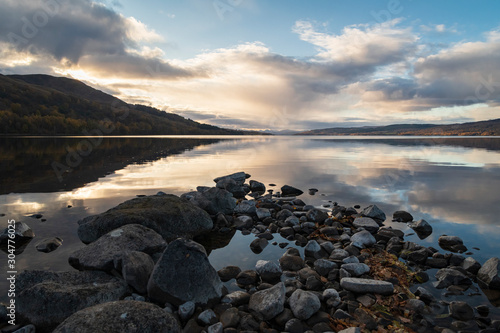An autumnal image of the calm waters of Loch Rannoch in afternoon sunlight, Perth and Kinross, Scotland.