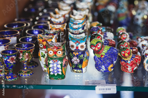 View of traditional tourist souvenirs and gifts from Beijing, China, with fridge magnets with text "China", and "Great Wall" miniature toys in local vendor souvenir shop in Panjiayuan Market