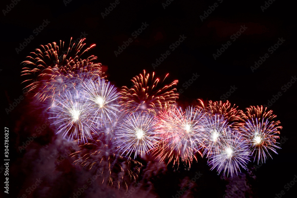 Flashes of red and purple fireworks against black sky Flashes of red and purple fireworks against black sky