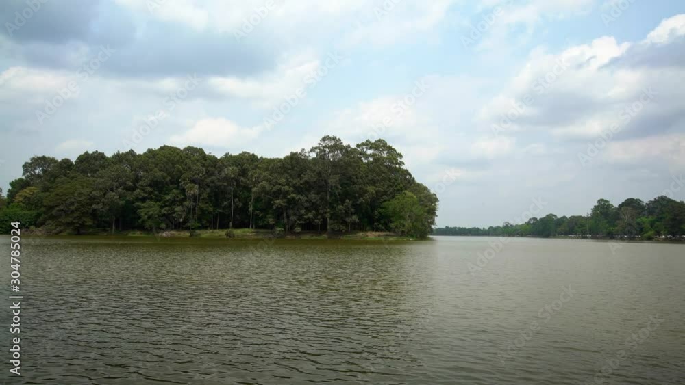 4K, Scenic view of the river around the Angkor Thom temple in Siem Reap, Cambodia. River surrounded by trees, reflection in the green water.-Dan 4K, Scenic view of the river around the Angkor Thom temple in Siem Reap, Cambodia. River surrounded by trees, reflection in the green water.-Dan