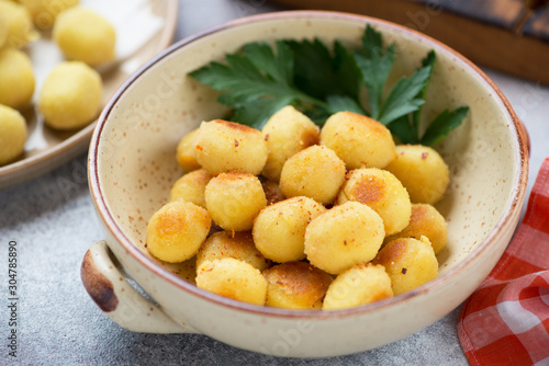 Beige bowl with italian pan fried potato gnocchi, close-up, selective focus