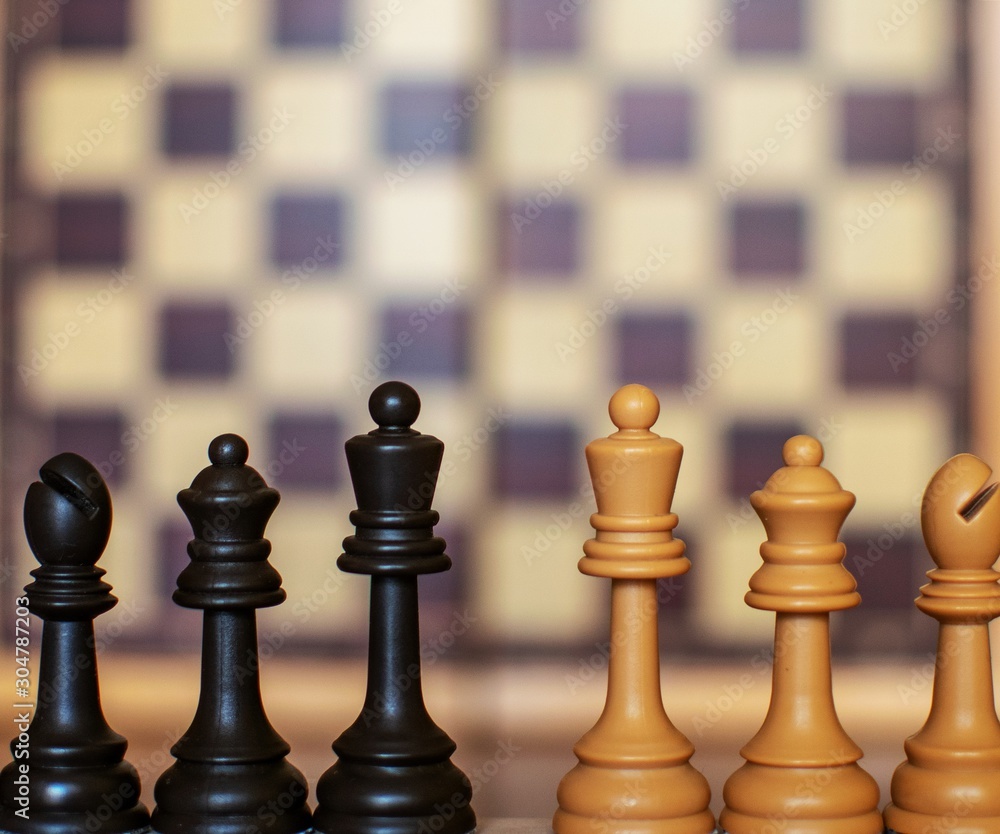 Premium Photo  Closeup of chess pieces on the chessboard under the lights  with a blurry background