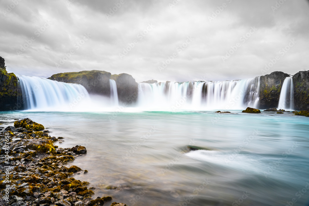 Godafoss waterfall, foggy from waterspray on a cloudy morning, Iceland