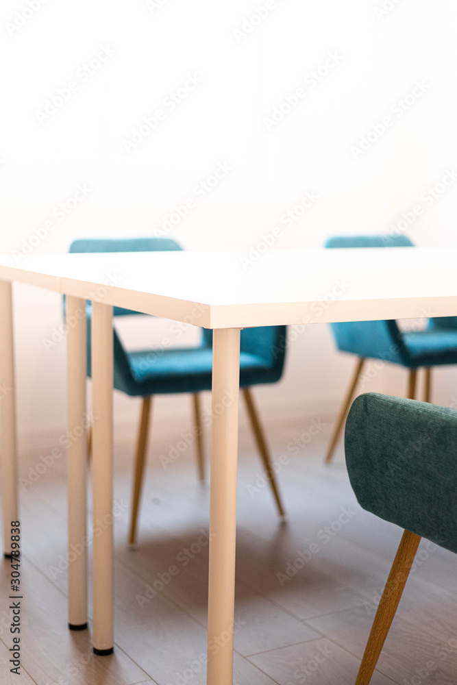 chaises bleu autour d'une table blanche carré de réunion dans un espace de coworking chaises bleu autour d'une table blanche carré de réunion dans un espace de coworking