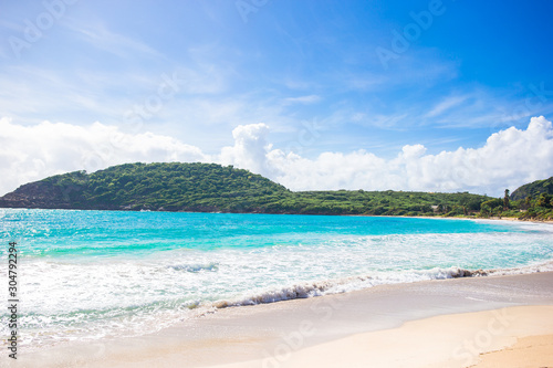 Idyllic tropical beach in Caribbean with white sand, turquoise ocean water and blue sky