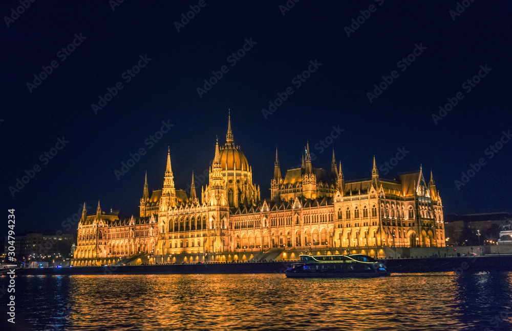 Budapest, Hungary - August 29, 2019: Hungarian Parliament building and Danube River in the   Budapest city at night. A sample of neo-gothic architecture, Budapest's tourist attraction