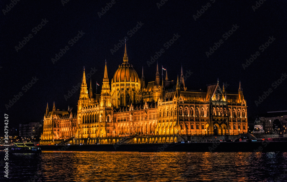 Budapest, Hungary - August 29, 2019: Hungarian Parliament building and Danube River in the   Budapest city at night. A sample of neo-gothic architecture, Budapest's tourist attraction