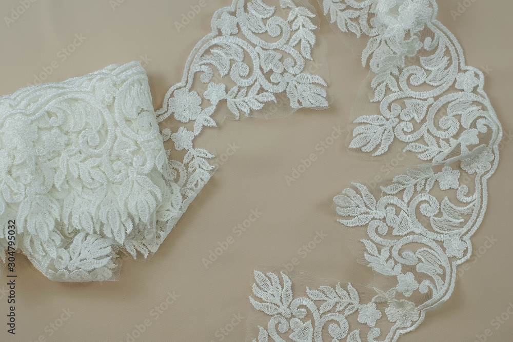 Obraz premium Texture lace fabric. lace on white background studio. thin fabric made of yarn or thread. a background image of ivory-colored lace cloth. White lace on beige background.