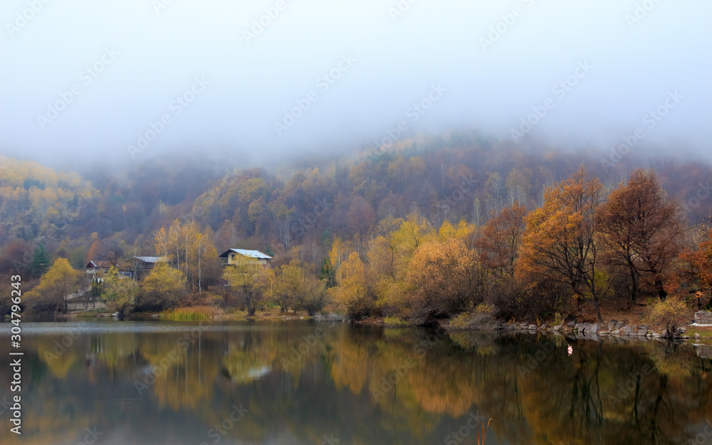 Fog over autumn forest and calm lake Fog over autumn forest and calm lake