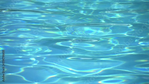 Clear water pool surface reflection waving and light sparkles.