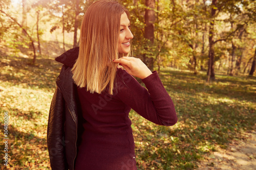 Portrait of beautiful elegant woman enjoying and posing in autumn day.