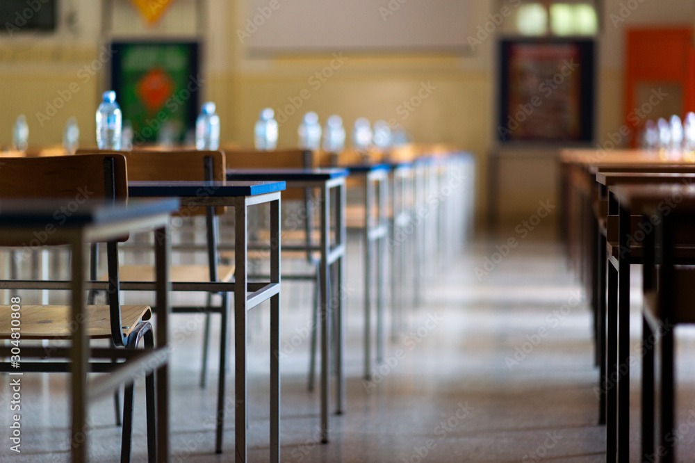 Exam examination room or hall set up ready for students to sit test. multiple desks tables and chairs. Education, school, student life concept. Exam examination room or hall set up ready for students to sit test. multiple desks tables and chairs. Education, school, student life concept.