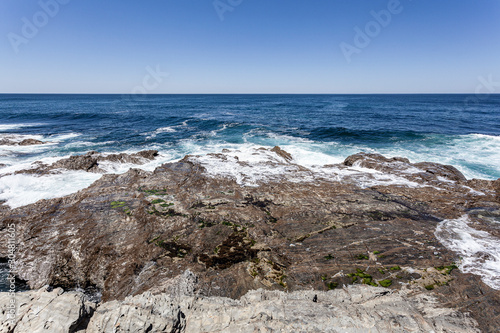 Rebentação das ondas do oceano no rochedo da costa.
