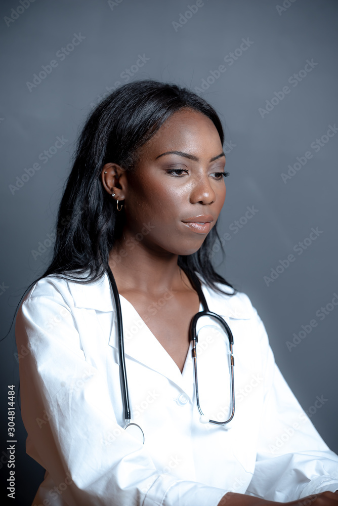 Medical scene african american Dr. of Pharmacy working with medications for patients on laptop with stethoscope around her neck wearing white lab coat. Medical scene african american Dr. of Pharmacy working with medications for patients on laptop with stethoscope around her neck wearing white lab coat.