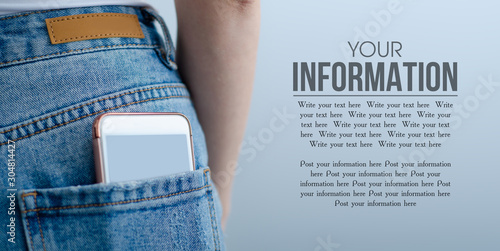 Woman puts mobile phone in jeans pocket on gray light background. Isolation, space for text