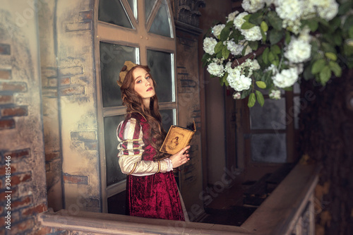 Redheaded woman with crown and old-fashioned  dress in flowers