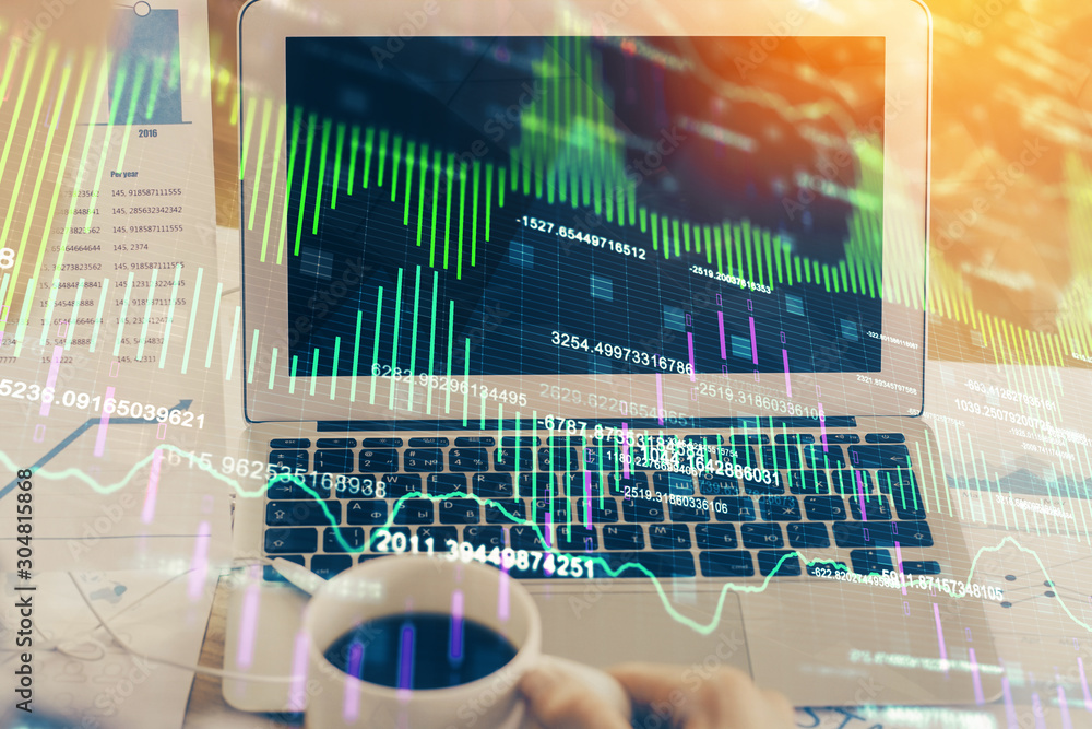 Financial chart drawing and table with computer on background. Double exposure. Concept of international markets. Financial chart drawing and table with computer on background. Double exposure. Concept of international markets.
