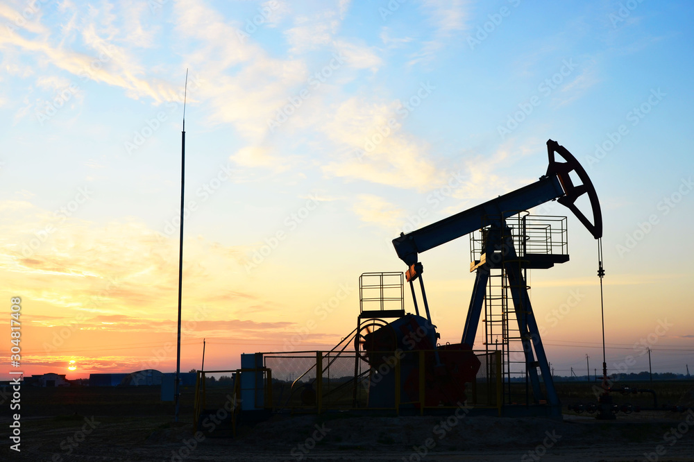 Oil drilling derricks at desert oilfield for fossil fuels output and crude oil production from the ground. Oil drill rig and pump jack. Oil drilling derricks at desert oilfield for fossil fuels output and crude oil production from the ground. Oil drill rig and pump jack.