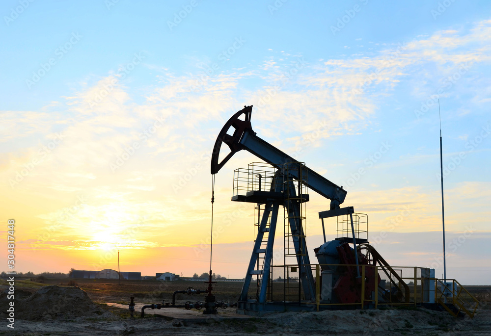 Oil drilling derricks at desert oilfield for fossil fuels output and crude oil production from the ground. Oil drill rig and pump jack. 